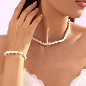 Detailansicht von handgefertigtem Muschel-Halsketten- und Armband-Set an einer Frau