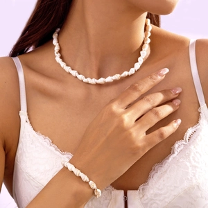 Nahaufnahme von Muschel-Halskette und Armband-Set, getragen an Hals und Handgelenk