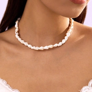 Nahaufnahme der weißen Muschelkette am Model im modernen böhmischen Strand-Stil