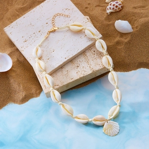 Dettaglio collana boho con conchiglie intrecciate e pendente a forma di capasanta