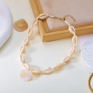 Dettaglio collana con conchiglie intrecciate e pendente in madreperla con catena d'oro