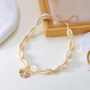 Dettaglio della collana bohémien con conchiglie, ciondolo di perle e chiusura d'oro