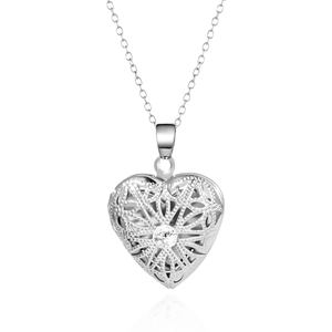 Gros plan du médaillon coeur argenté avec motif ajouré et cristal central brillant