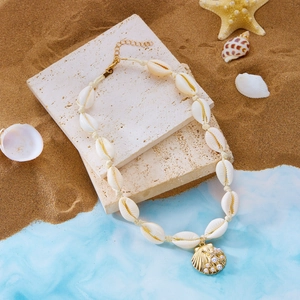 Dettaglio della collana boho con conchiglie e ciondolo a conchiglia dorata con perla