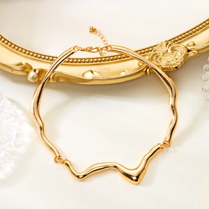 Detail eines goldenen Lava-Chokers mit unregelmäßiger Wellenstruktur und Karabinerverschluss