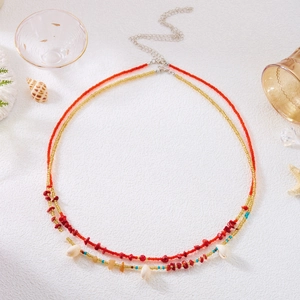 Detail of bohemian waist chain featuring natural shells and red gravel on white texture
