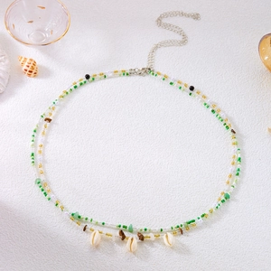 Detail of beach waist chain with green beads, stones and white natural cowrie shells