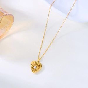 Collier médaillon cœur doré avec motif floral ajouré et pierre de cristal étincelante