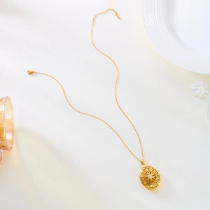 Collier médaillon doré vintage avec motif évidé et petite pierre précieuse centrale
