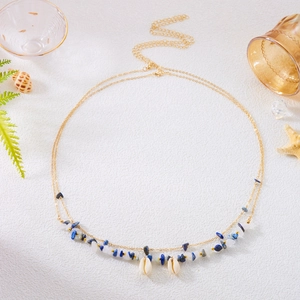 Detail of bohemian gold waist chain with blue gravel beads and natural white seashells