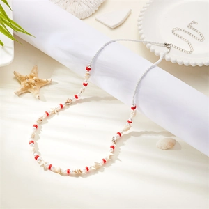 Detail showing shell and starfish charms on a beaded waist chain for beach wear