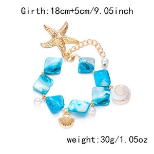 Detail view of gold starfish and shell charms with blue beads on a chunky chain necklace