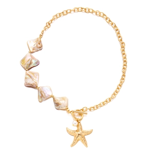 Detail of bohemian gold necklace with seashell tiles, starfish pendant and toggle clasp