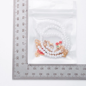 Nahaufnahme der Erdbeer-Perlenhalskette in transparenter PE-Schutzverpackung