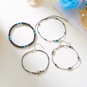 Close-up of four-piece beach anklet set with turtle charm and turquoise beads
