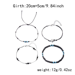 Detailed view of multilayer anklet set featuring turtle charm and black beaded strands