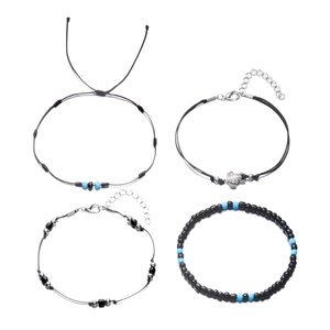 Detail of multi-layer beach anklet set featuring a silver turtle charm and blue beads