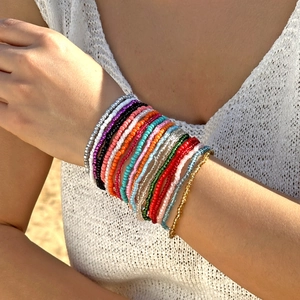 Detailopname van een Boheemse meerkleurige kralenarmbandset gedragen op de pols
