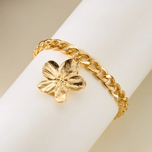 Détail du bracelet à fleur dorée avec pétales texturés et grosse chaîne de style gourmette