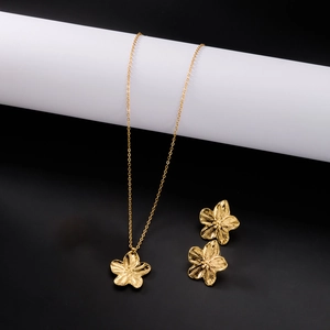 Détail de parure bijoux fleur dorée avec pétales brossés et finition élégante