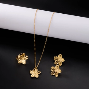 Vue détaillée de l'ensemble de bijoux avec collier, boucles et bague fleurs dorées