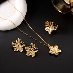 Détail macro d'une parure de bijoux fleur dorée avec des pétales texturés au stand