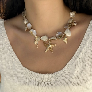 Close-up of ocean-themed necklace with starfish, seahorse, and shell charms on pearls
