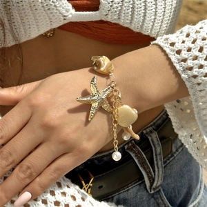 Close-up of bohemian gold starfish and shell beaded layered necklace on female model