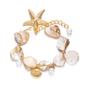Detailed macro view of bohemian ocean-themed necklace with gold starfish and pearl accents
