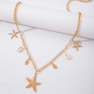 Detail der goldenen Strand-Taillenkette mit Seestern-Anhängern und weißen Naturmuscheln