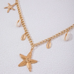 Nahaufnahme der goldenen Strand-Taillenkette mit Muschel- und Seestern-Anhängern