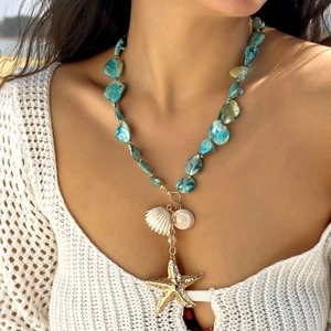 Blue shell beaded necklace with gold starfish and sea shell charms on a female model