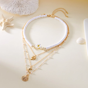 Detail of layered ocean theme necklace with starfish, coconut tree and shell pendants
