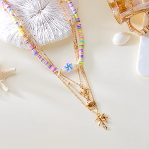Detail of layered bohemian necklace with colorful clay beads and sea life metal pendants