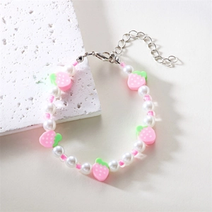 Dettaglio del bracciale di perle con fragole rosa e chiusura a moschettone in argento