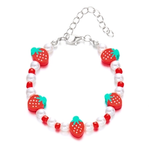 Dettaglio del bracciale con perle e fragole con ciondoli in argilla rossa e moschettone