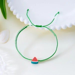 Makro-Detail von handgewebtem Wassermelonen-Armband mit verstellbarer grüner Kordel