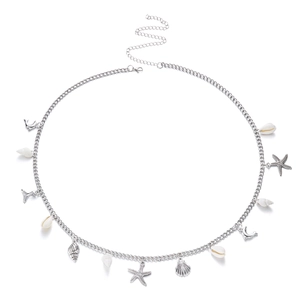 Detailed close-up of a silver body chain with starfish and shell pendants on white