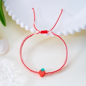 Detailansicht des handgewebten Erdbeer-Armbands mit verstellbarer rot-weißer Kordel