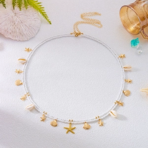 Detail of beaded waist chain featuring gold starfish, shell charms, and lobster clasp