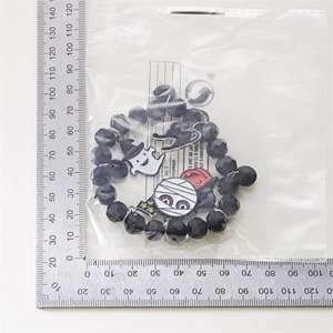 Detalle de pulsera de Halloween con colgantes de calabaza, fantasma y gato negro