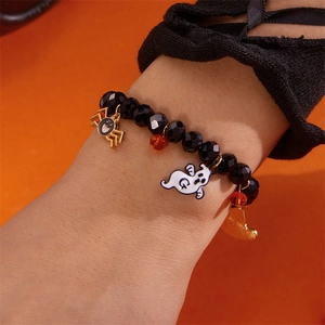 Primer plano de pulsera de Halloween con cuentas negras, araña de oro y fantasma