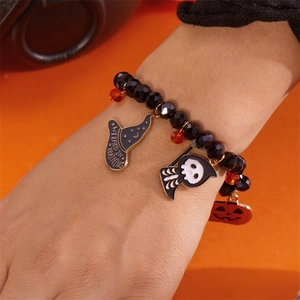 Pulsera de Halloween con dijes de sombrero de mago y calabaza usada en la muñeca