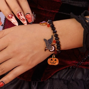 Detalle de pulsera de Halloween con cuentas, dijes de calabaza y sombrero de mago