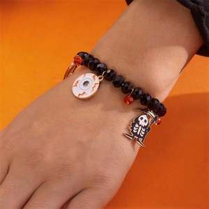 Primer plano de pulsera de Halloween con cuentas negras y colgante de calavera