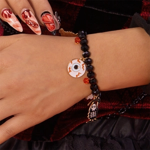 Pulsera de Halloween con cuentas negras y colgantes de calavera y ojo en la muñeca