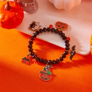 Pulsera de cuentas de Halloween con dijes de calabaza y araña en fondo festivo