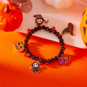 Detalle macro de pulsera de Halloween con dijes de calabaza fantasma y sombrero
