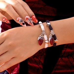 Gothic-Armbänder mit Herzanhängern und Sternperlen am Handgelenk eines Models