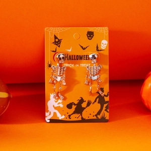 Detailed view of silver skeleton tassel earrings displayed on a festive Halloween card